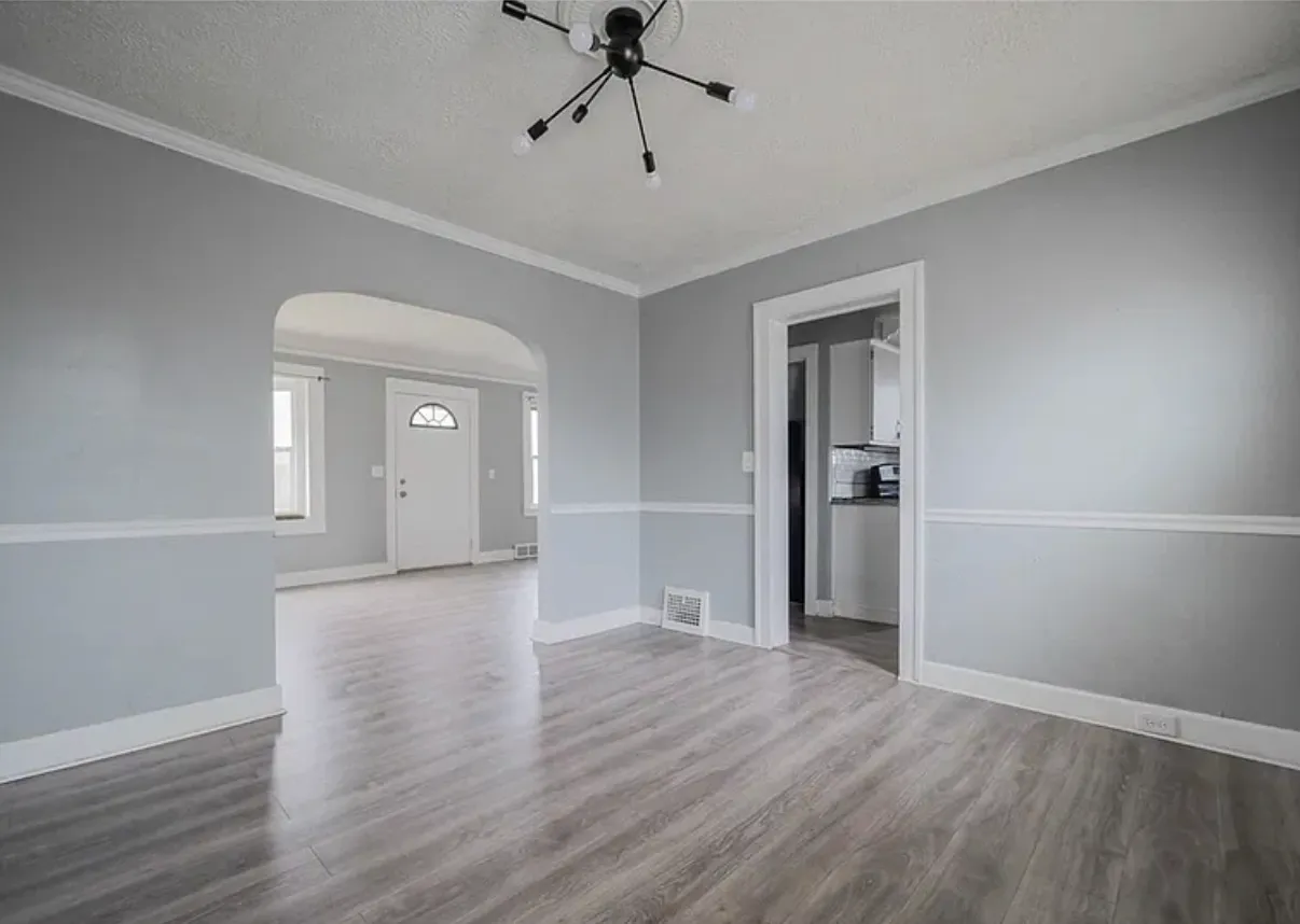 Dining room with crown moulding and an arched opening through to the entry