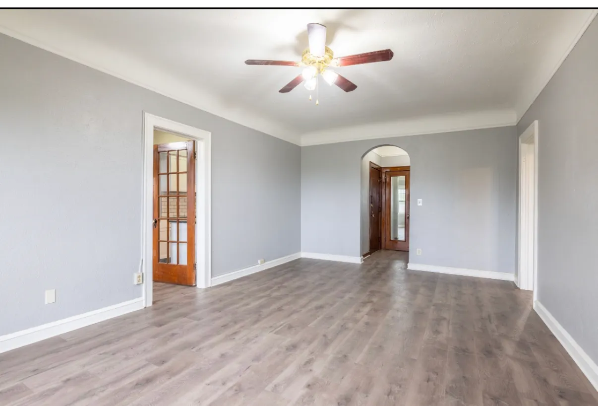 Living room with original wood and glass doors and an arched plaster opening